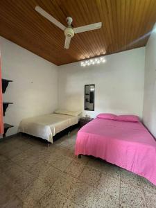 a bedroom with two beds and a ceiling fan at Casa de los Colores in Honda