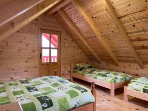 a bedroom with two beds in a log cabin at Brvnare Cirkovic in Zlatibor