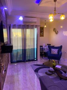 sala de estar con iluminación púrpura, sofá y mesa en Residence Adja Binta Kane Sour en Dakar