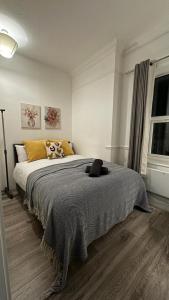 a bedroom with a bed with a gray blanket at Wandsworth Guest Rooms 64 in London