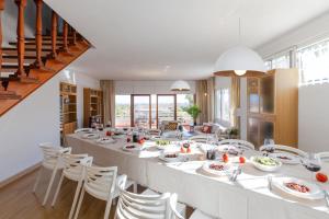 una sala da pranzo con un lungo tavolo e sedie bianche di Urban Elegance by Fidalsa ad Alicante