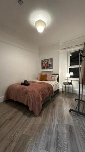 a bedroom with a large bed with a wooden floor at Wandsworth Guest Rooms 64 in London