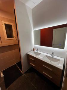 uma casa de banho com 2 lavatórios e um espelho grande em Maison chaleureuse avec jardin em Bourges