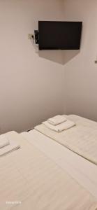 Una cama blanca con dos toallas blancas. en Gostinstvo Tomex, en Ilirska Bistrica