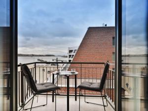 a balcony with two chairs and a table on a balcony at Ohlerich Speicher App_ 12 in Wismar