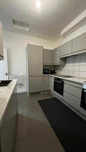 a kitchen with white cabinets and a black rug at Wandsworth Guest Rooms 64 in London
