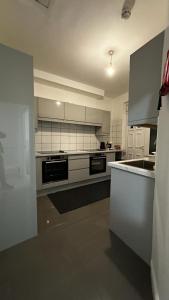 a large kitchen with white cabinets and appliances at Wandsworth Guest Rooms 64 in London