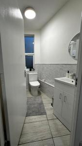 a bathroom with a toilet and a sink at Wandsworth Guest Rooms 64 in London