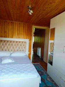 een slaapkamer met een wit bed en een houten plafond bij Rize Doğa Home 