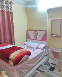 ein Kinderschlafzimmer mit einem rosa und weißen Bett in der Unterkunft Furnished Apartment in al-Minya