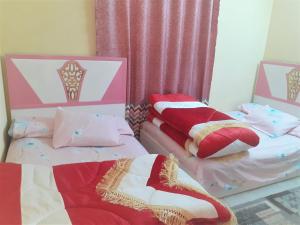 dos camas sentadas una al lado de la otra en una habitación en Furnished Apartment en Al Minya