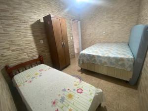 una piccola camera con due letti e un armadio di Casa com Piscina Bertioga a Bertioga