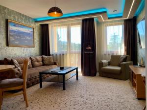 Deluxe Apartment 33 Mountain Lodge Pamporovo في بامبوروفو: غرفة معيشة مع أريكة وطاولة