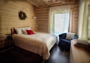 ein Schlafzimmer mit einem Bett, einem Stuhl und einem Fenster in der Unterkunft SVILPJI Lakeside Retreat House in a Forest with all commodities in Amatciems