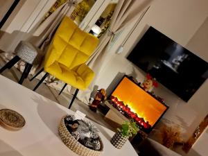 a living room with a yellow fireplace and a yellow chair at Villa Filarety Luxury House in Thessaloniki