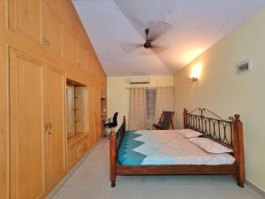 um quarto com uma cama e uma ventoinha de tecto em Vintage Haven By Spacez near Indranagar Metro Station em Bangalore