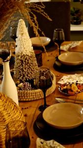 a wooden table topped with plates and a christmas tree at Villa Filarety Luxury House in Thessaloniki