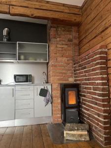 a kitchen with a brick wall and a stove at Cosy studio near Aqva Spa in Rakvere