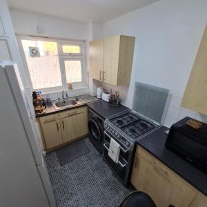 a small kitchen with a stove and a sink at Studio apartment in London, Bethnal Green in London
