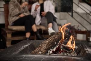 grupa ludzi siedzących wokół ogniska w obiekcie Villa Filarety Luxury House w Salonikach