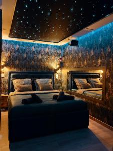una camera con due letti e una parete con stelle di Le Quai Amiénois - Romance Tropicale - SPA Romantique ad Amiens