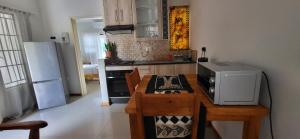 a kitchen with a table with a microwave and a refrigerator at Maun Luxury Oasis in Maun