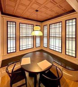 a dining room with a table and chairs and windows at CoHouse New Haven steps to Yale University in New Haven