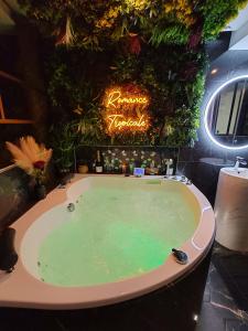 una vasca idromassaggio in una stanza con piante di Le Quai Amiénois - Romance Tropicale - SPA Romantique ad Amiens