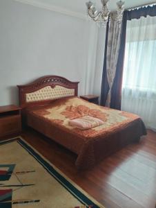 a bedroom with a bed and a chandelier at Сдается 2-комнатная квартира в центре города in Atyrau
