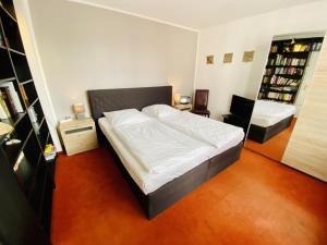 a bedroom with a large bed with white sheets at Ferienhaus Maria in Warnemünde