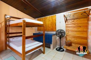 a bunk bed room with two bunk beds and a fan at Hostel Chapada Dos Guimarães in Chapada dos Guimarães