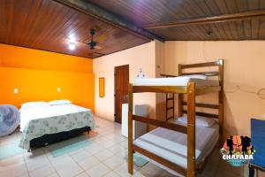 two bunk beds in a room with yellow walls at Hostel Chapada Dos Guimarães in Chapada dos Guimarães