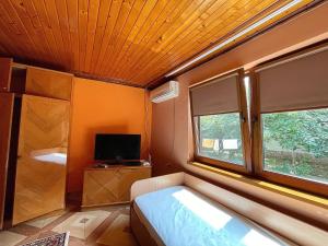a bedroom with a bed and a tv and a window at Приватний будинок in Berehove