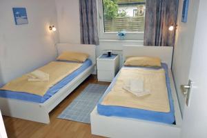 ein kleines Zimmer mit 2 Betten und einem Fenster in der Unterkunft Voßhörn 27 Whg. 3 in Cuxhaven