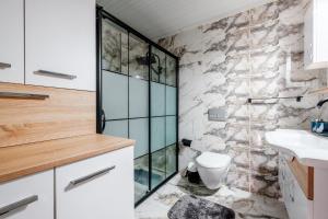 uma casa de banho com uma cabina de duche em vidro e um WC. em Modern Flat 5 min to Mahmutlar Beach in Alanya em Mahmutlar