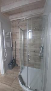 La salle de bains est pourvue d'une douche avec une porte en verre. dans l'établissement KANALOA, à Pobierowo