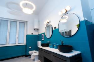 a blue bathroom with a sink and a mirror at Pop House - Spacious flat next to Cathedral & Lake in Como