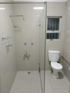 Un baño blanco con inodoro y ducha. en Cape Town 5 bedroom house Belhar, en Ciudad del Cabo