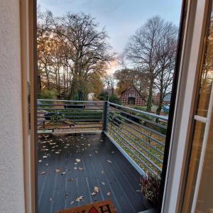 - une vue depuis la porte d'une terrasse couverte avec des feuilles au sol dans l'établissement Bei Conny und Bernd, à Barnstorf