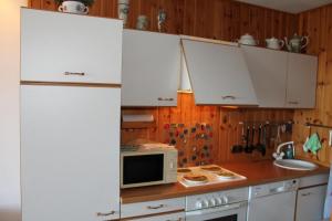 a kitchen with a white refrigerator and a microwave at Ferienwohnung L417 für 2-4 Personen an der Ostsee in Schönberg in Holstein