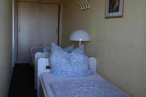 Schönberg in HolsteinにあるFerienappartement E222 für 2-4 Personen an der Ostseeのベッドルーム1室(青い枕とランプ付きのベッド1台付)