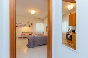 a view of a bedroom with a bed and a kitchen at HappyHouse MI MPX a 7 min da MXP in Busto Arsizio