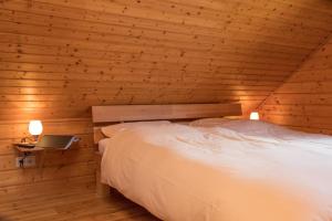 a bedroom with a bed in a wooden cabin at Ferienhaus 08 Blauvogel in Hasselfelde