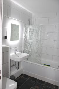 ein weißes Bad mit einem Waschbecken und einer Dusche in der Unterkunft Ferienwohnung Ostsee F414 in Schönberg in Holstein