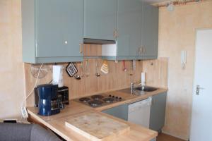 eine Küche mit blauen Schränken und einer Arbeitsplatte in der Unterkunft Ferienwohnung L435 für 2-4 Personen an der Ostsee in Schönberg in Holstein