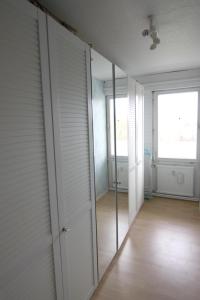 ein leeres Zimmer mit weißen Türen und einem Spiegel in der Unterkunft Ferienwohnung L435 für 2-4 Personen an der Ostsee in Schönberg in Holstein