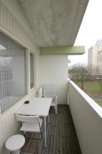 eine Veranda mit einem Tisch und Stühlen auf dem Balkon in der Unterkunft Ferienwohnung L435 für 2-4 Personen an der Ostsee in Schönberg in Holstein