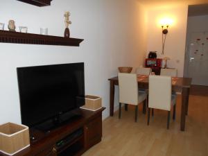 un soggiorno con TV e tavolo con sedie di Ferienappartement E417 für 2-4 Personen an der Ostsee a Schönberg in Holstein