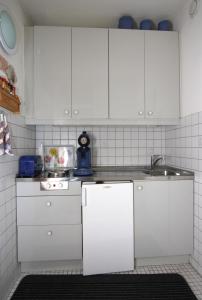 una cocina con armarios blancos y fregadero en Ferienwohnung L412 für 2-4 Personen an der Ostsee, en Schönberg in Holstein