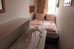 ein kleines Zimmer mit 2 Betten und einem Fenster in der Unterkunft Ferienwohnung L412 für 2-4 Personen an der Ostsee in Schönberg in Holstein